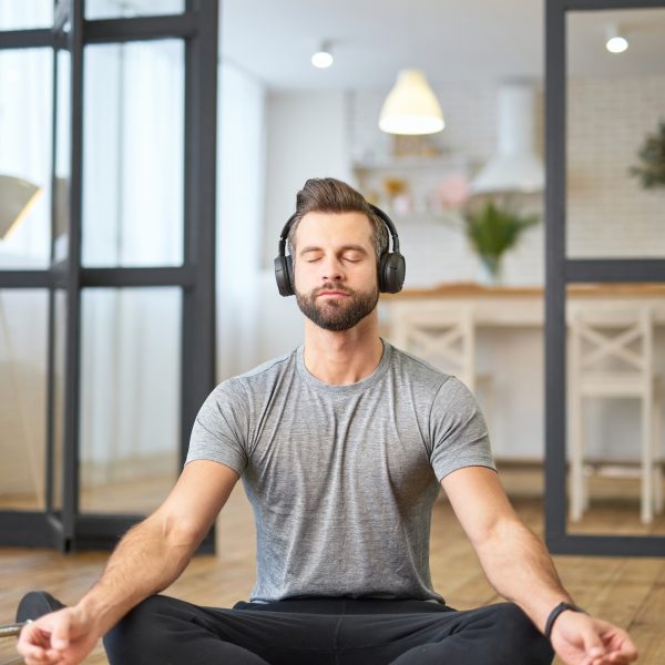 Bearded young man listening to music and meditating