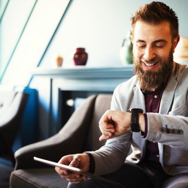 Business and time management concept. Happy business man looking at wrist watch